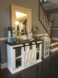 the entryway is decorated in white and wood