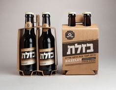 three bottles of beer sitting next to a cardboard box with the word hebrew written on it