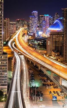 the city skyline is lit up at night with long exposure and blurry lights on it