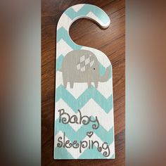 a wooden door hanger that says baby sleeping with an elephant on it's back