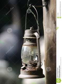 an old metal lantern hanging from a wooden pole stock photo - image 349784