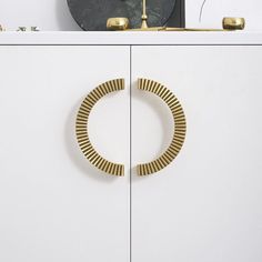 a white cabinet with a gold ring on it