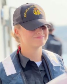 a woman police officer is smiling and looking at the camera while she's wearing a hat