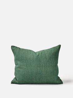 a green pillow sitting on top of a white wall