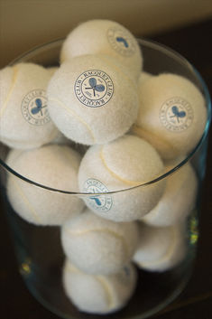 a glass bowl filled with white tennis balls