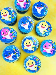 cupcakes decorated with blue frosting and various cartoon characters on them are arranged in a circle