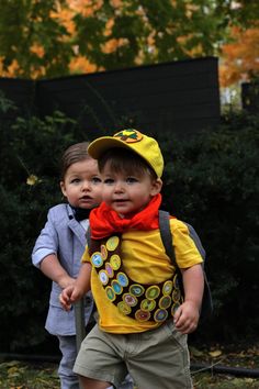 two small children are walking in the grass