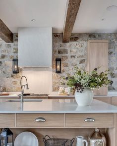 a kitchen with stone walls and white counter tops