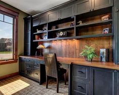 a home office with built - in desk and bookcases next to a large window