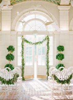 an instagramted photo shows the ceremony room decorated with greenery and white chairs