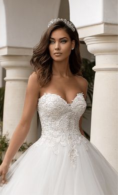 a woman in a white wedding dress posing for the camera