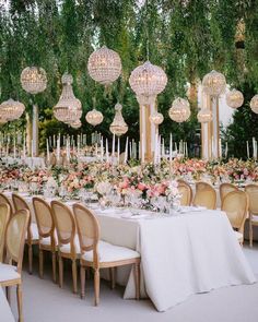 an outdoor wedding reception with chandeliers and tables set up for a formal function