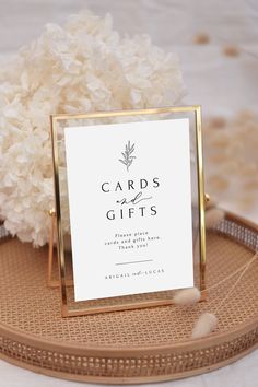 there is a card on the table with flowers in front of it and a sign that says cards and gifts