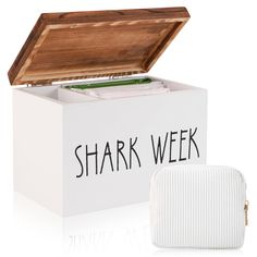 a white box with a wooden lid and the words shark week written on it, next to an empty case