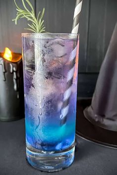 a tall glass filled with blue liquid and a green sprig