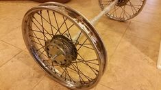 two wheel spokes on the ground in a room with tile flooring and tiled walls