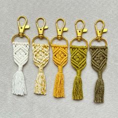 four key chains with tassels in different colors and patterns on each one side