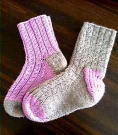 two pairs of socks sitting on top of a wooden table