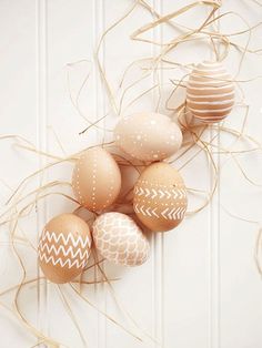 some eggs are laying on the floor next to some grass and paper decorations with gold ribbons