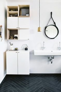 a bathroom with two sinks, a mirror and shelves on the wall next to each other