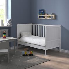 a child's bedroom with a white bed and gray walls