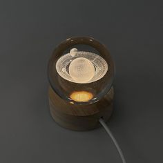 a lamp that is on top of a wooden base with a light bulb in the middle