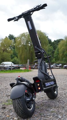 an electric scooter is parked on the gravel