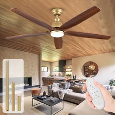 a person holding a remote control in front of a living room with a ceiling fan