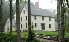 a white house surrounded by trees and rocks