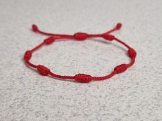 a red string bracelet sitting on top of a table