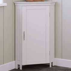 a small white cabinet with a basket on top