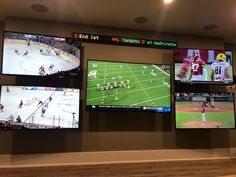 four televisions mounted to the wall in a sports facility with video screens on them