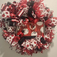 a red and white wreath with ladybugs on it