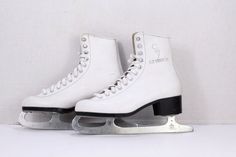 two white ice skates sitting on top of each other