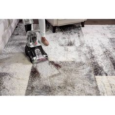 a person using a vacuum to clean carpet