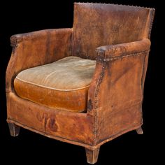 an old leather chair with a brown cushion