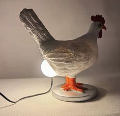 a white and orange chicken lamp on top of a table