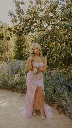 a woman in a pink dress posing for the camera with her hands on her hips