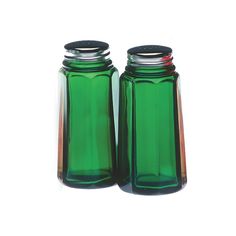 two green glass jars sitting next to each other