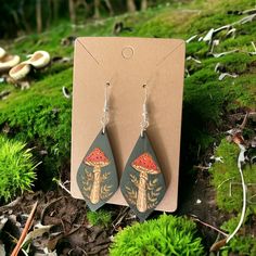 Wood engraved earrings with red capped mushrooms, leaves, and a dark green background. Fun Earrings Unique, Hand Painted Earrings Wood, Art Hacks, Engraved Earrings, Mushroom Earrings, Hand Painted Earrings, Nature Earrings, Painted Earrings, Road Design