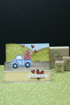 some cards are sitting on a table with two rubber stamps and one has a blue truck