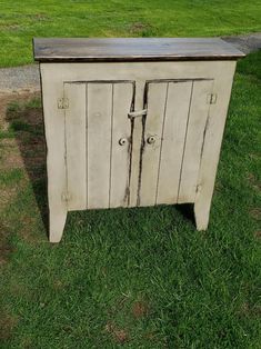 an old wooden cabinet sitting in the grass