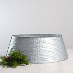 a silver tin can sitting on top of a wooden table next to a planter