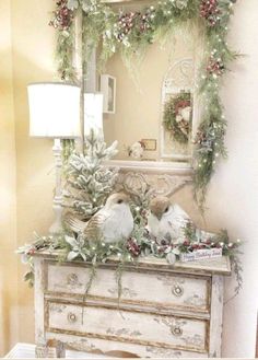 a white dresser topped with christmas decorations and birds sitting on it's sideboard