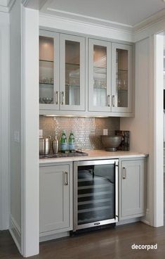 a kitchen with white cabinets and wood flooring in the middle of it is shown