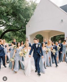 a bride and groom walking with their bridal party in front of the chapel at this wedding