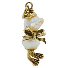 An adorable pearl duckling charm, featuring 10k gold. The head and body of the duckling is created from two pearls connected by the gold bow sitting on the charm’s neck. The head is topped with a gold baseball hat, and the legs are gold as well. These tiny accents add a chic touch to the lustrous pearl. Whether worn as a pendant or attached to a charm bracelet, this pearl duck is a playful nod to vintage craftsmanship with a lot of personality. CIRCA: 1990’s MATERIALS: 10K Yellow Gold GEMSTONE: Pearl WEIGHT: 4 grams MEASUREMENTS: 1” x 3/8” Pisces Pendant, Anchor Jewelry, 10k Gold Chain, Anchor Pendant, Gold Caps, Brooch Necklace, Beaded Choker Necklace, Pearl Charms, Yellow Gold Chain