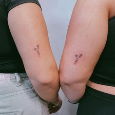 two women with small tattoos on their arms