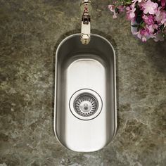 a stainless steel sink in the middle of a granite counter top with flowers on it