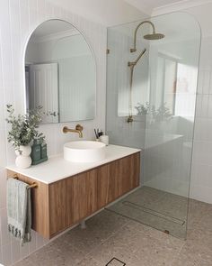 a bathroom with a sink, mirror and shower